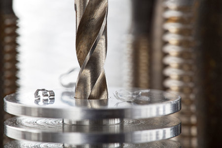 metal drill bit make holes in aluminum radiator on industrial drilling machine. metal work industry.