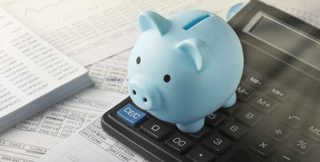 Moneybox for money on the background of documents and financial charts. Investment and capital accumulation concept.の写真素材