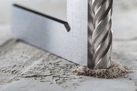 drill bit make holes in concrete wall with steel triangle. building work industry.