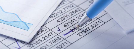Accounting document with pen, money, coins and checking financial chart. Concept of banking, financial report and financial audit.の写真素材