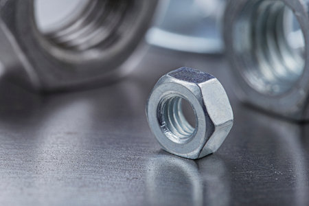 set of different nuts, bolts, screws, washers and drill bits, thread tap and mill cutters on steel plate background. locksmithing deal.の写真素材