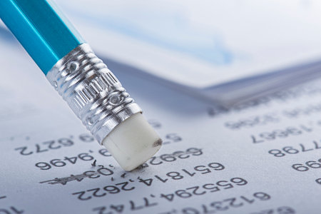 Accounting document with eraser erases blots in the document and checking financial chart. Concept of banking, financial report and financial audit.の写真素材