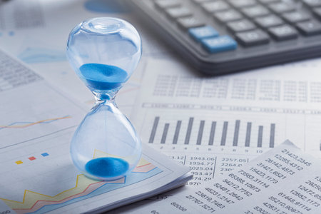 Best time for investment. Hourglass, financial charts and calculator.の写真素材