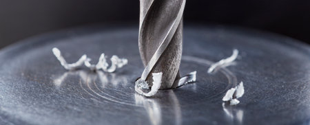 metal drill bit make holes in steel billet on industrial drilling machine. metal work industry. multi cutting tool and end mill.の写真素材