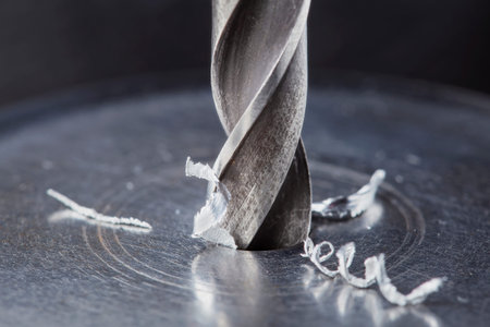 metal drill bit make holes in steel billet on industrial drilling machine. metal work industry. multi cutting tool and end mill.の写真素材