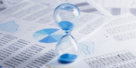 Best time for investment. Hourglass, financial charts and calculator.