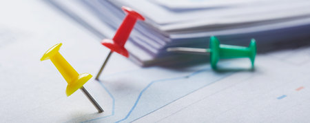 Marking financial chart by pins. Concept of banking, financial report and financial audit.
