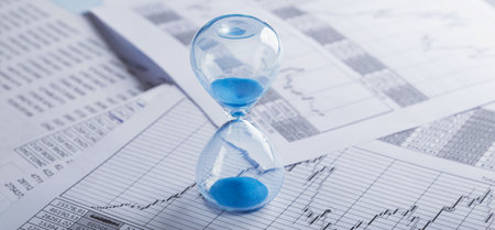 Best time for investment. Hourglass, financial charts and calculator.の写真素材