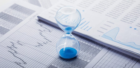 Best time for investment. Hourglass, financial charts and calculator.