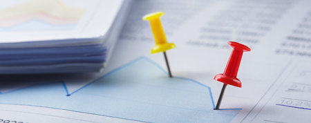 Marking financial chart by pins. Concept of banking, financial report and financial audit.の写真素材