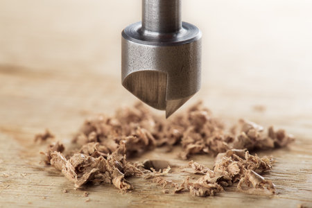 Countersink drill bit with steel triangle ruler make sink in hole for screw in wooden oak plankの写真素材