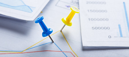 Marking financial chart by pins. Concept of banking, financial report and financial audit.