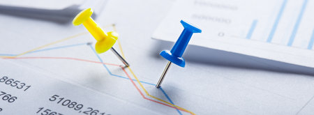Marking financial chart by pins. Concept of banking, financial report and financial audit.の写真素材