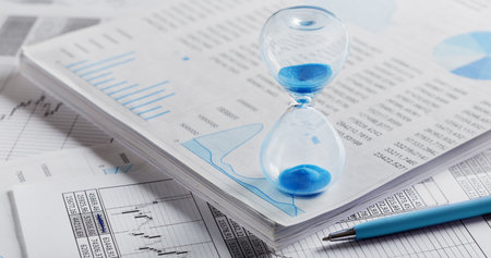 Best time for investment. Hourglass, financial charts and calculator.の写真素材