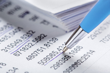 Accounting document with pen, money, coins and checking financial chart. Concept of banking,...