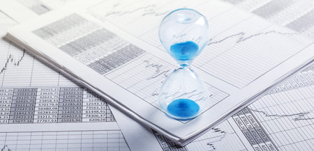 Best time for investment. Hourglass, financial charts and calculator.