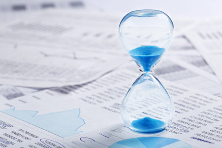Best time for investment. Hourglass, financial charts and calculator.