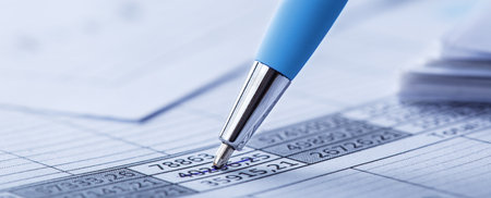 Accounting document with pen, money, coins and checking financial chart. Concept of banking, financial report and financial audit.の写真素材