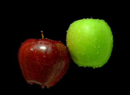 two apples red and green in water on a black backgroundの写真素材
