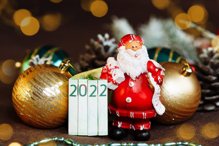 toy Santa Claus with Christmas decorations and money in the form of 2022