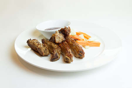 Close up view of barbecue ribs with fries and sauce on a old wooden tableの写真素材