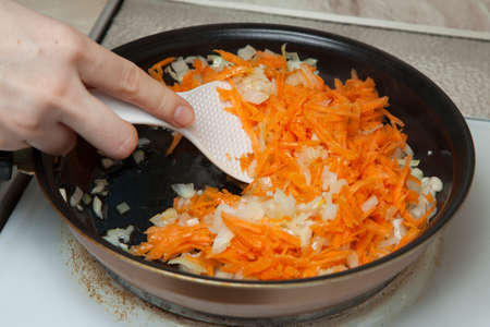 onions, carrots and garlic in a pan with sunflower oilの写真素材