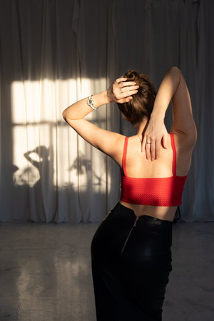 girl in a red knitted swimsuit on a background of curtains