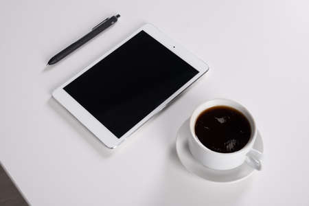 digital tablet and coffee cup on wooden tableの写真素材