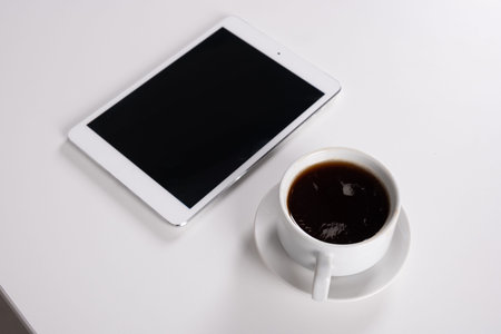 digital tablet and coffee cup on wooden table