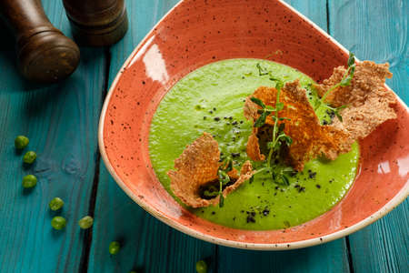 Cream of green pea soup decorated with edible chipsの写真素材