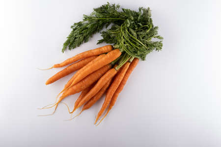 fresh BUNCH OF CARROT close up isolated on white backgroundの写真素材