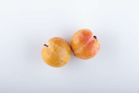 Juicy yellow plums with leaves, isolated on white background.の写真素材