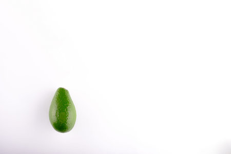 Brazilian green avocado close up in the lower left corner of the white backgroundの写真素材