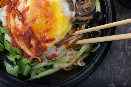 Korean dish bibimbap. Top view close up. Nearby are the Korean sticks.