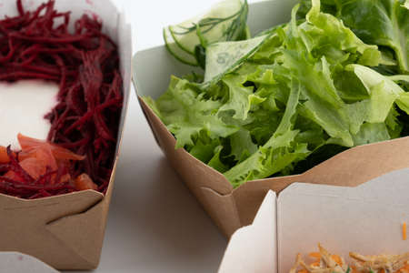 a set of different salads for vegetarians and raw foodists ready to eat in cardboard platesの写真素材