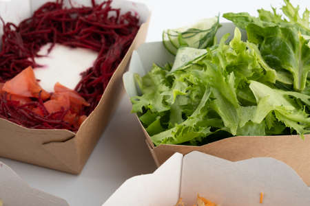 a set of different salads for vegetarians and raw foodists ready to eat in cardboard platesの写真素材