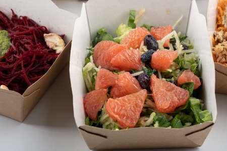 a set of different salads for vegetarians and raw foodists ready to eat in cardboard platesの写真素材