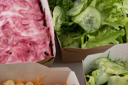 a set of different salads for vegetarians and raw foodists ready to eat in cardboard platesの写真素材
