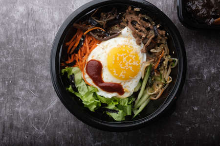 Korean dish bibimbap. Top view close up. Nearby are the Korean sticks.の写真素材
