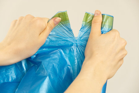 Female hands hold trash bags.