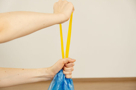 Female hands hold trash bags.