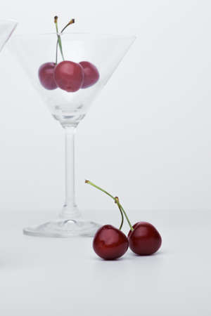  Cherry in a martini glass. Close-up for a screensaver. Nearby lies a cherry.の写真素材