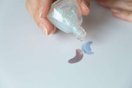 Nail polish. Female hands make strokes of varnishes of different colors. view from above. Mix with sparkles.の写真素材