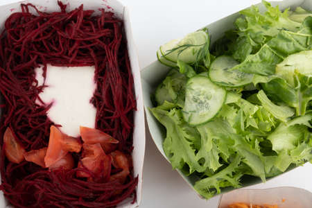 a set of different salads for vegetarians and raw foodists ready to eat in cardboard platesの写真素材