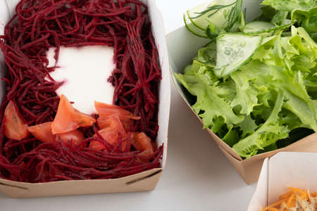 a set of different salads for vegetarians and raw foodists ready to eat in cardboard platesの写真素材