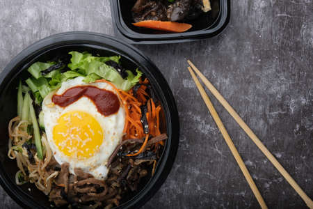 Korean dish bibimbap. Top view close up. Nearby are the Korean sticks.の写真素材