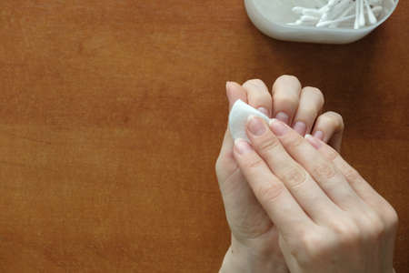  Manicure at home. Female hands use nail polish remover at home close up with manicure set. View from aboveの写真素材
