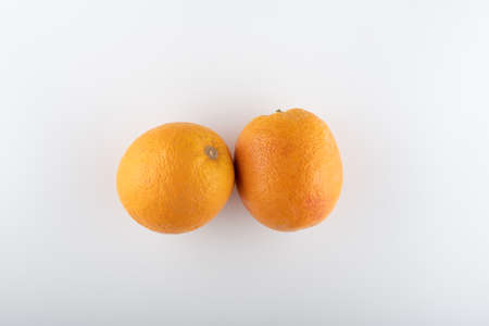 ripe oranges with sliced halves close-up on a white backgroundの写真素材