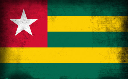 The flag of Togo was adopted on April 28, 1960. It has five equal horizontal bands of green top and bottom alternating with yellow. There is a white five-pointed star on a red square in the upper hoist-side corner. It uses the popular pan-African colors oの写真素材