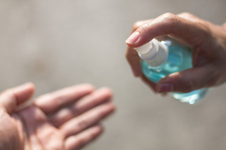 Hands applying alcohol spray anti virus and bacteria.